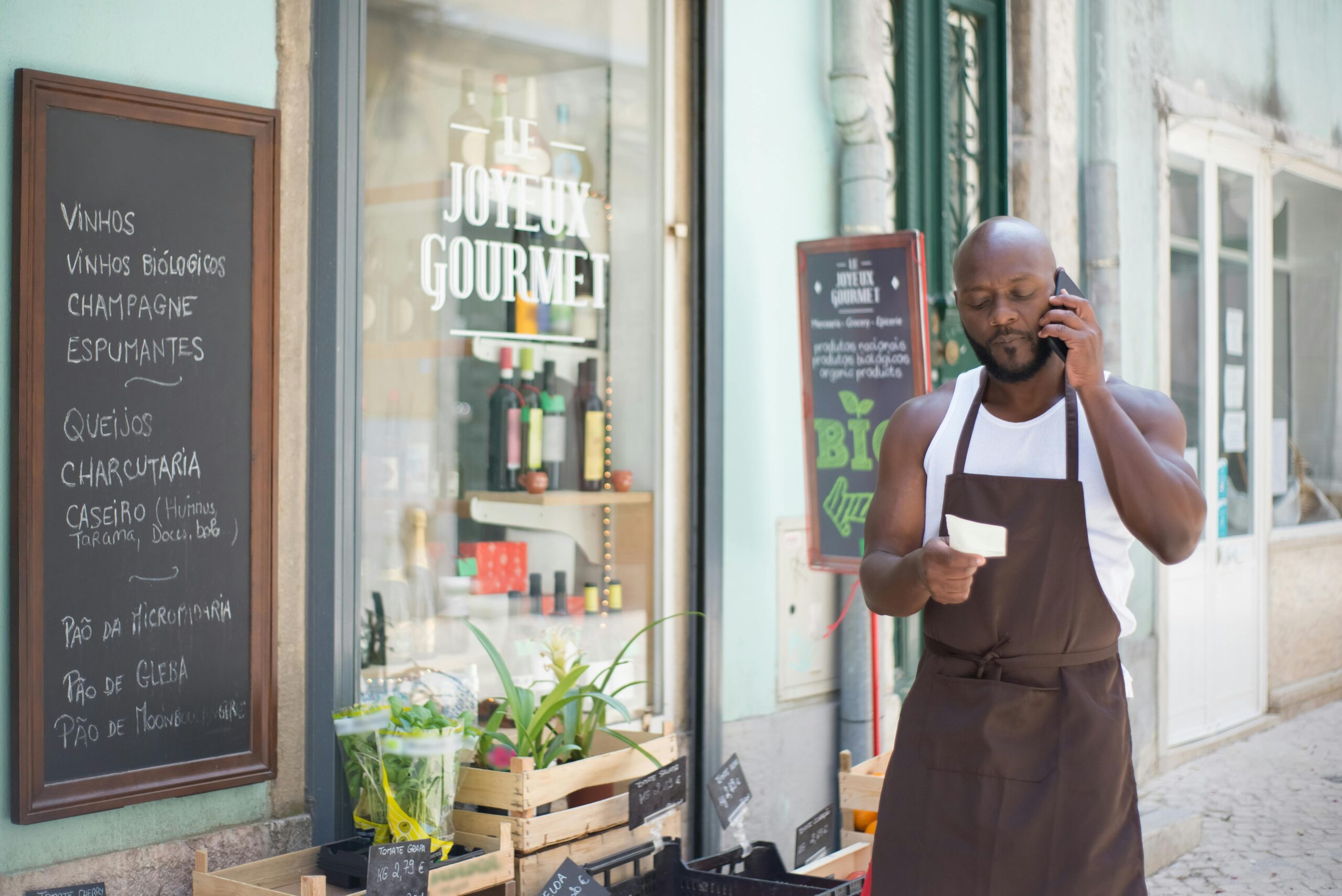 A grocery store vendor making a phone call at a gourmet shop in Lisbon, Portugal.